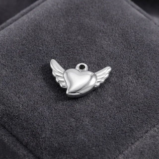 Silver heart-shaped pendant with wings on a dark gray background