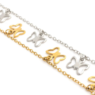 Butterfly-shaped charms on gold and silver chains against a white background