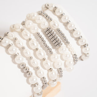 Set of pearl and silver beaded bracelets on a white background