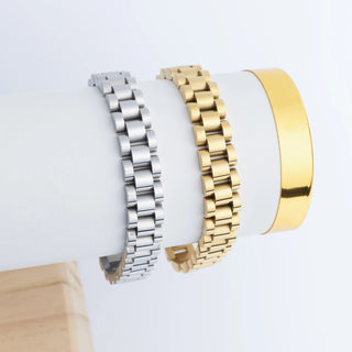 Three metal bracelets in silver, gold, and rose gold on a white surface.