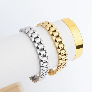 Two watch bracelets, one silver and one gold, on a white background
