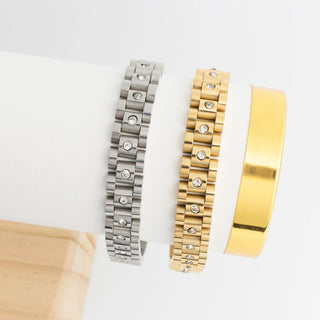 Two metallic watch bracelets, one silver and one gold, on a white background.