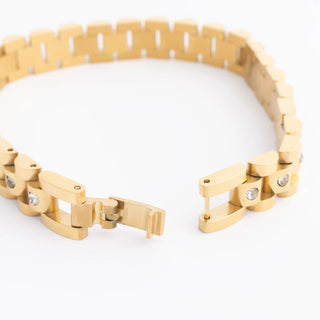 Gold bracelet with diamond accents on a white background