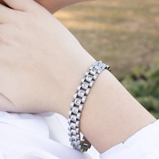 Silver bracelet on a wrist with a blurred natural background