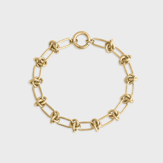 Gold chain bracelet on a light gray background