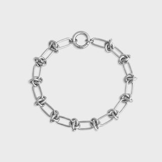 Silver chain bracelet on a light gray background
