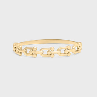 Gold chain bracelet on a light gray background