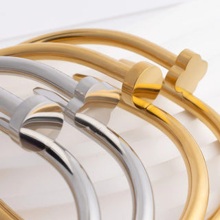 Two gold and silver bracelets on a light background