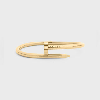 Gold bracelet on a light gray background