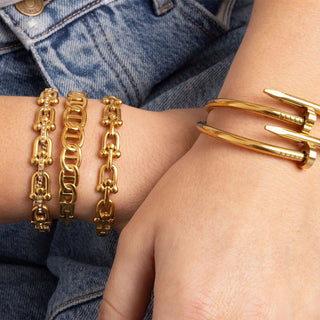 Gold bracelets on a wrist with denim background