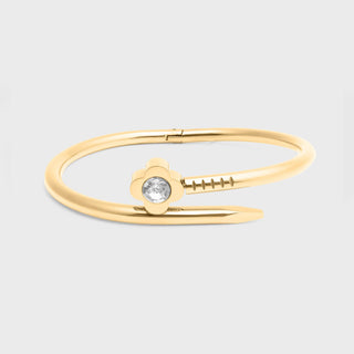 Gold bracelet with a central gemstone on a light gray background