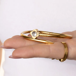 Gold bracelet with a diamond on a hand against a white background