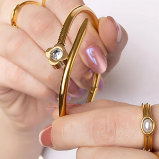 Gold bracelet with a diamond on a white background