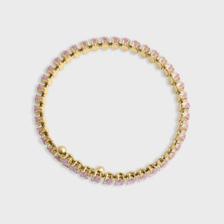 Gold bracelet with pink stones on a light gray background