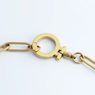 Gold chain necklace on a light gray background