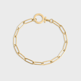 Gold chain bracelet on a light gray background