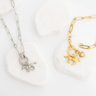 Gold and silver necklaces with horse charms on a white background