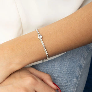 Silver bracelet on a wrist with a white background