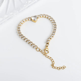 Gold bracelet with heart-shaped clasp on a white background