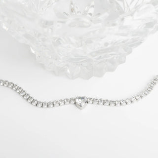 Silver bracelet with a heart-shaped clasp on a white background