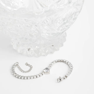 Silver bracelet with heart charm on a white background