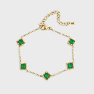 Gold bracelet with green gemstones on a white background