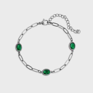 Silver bracelet with green gemstones on a white background