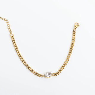 Gold chain necklace with a single diamond on a white background