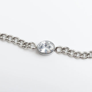 Silver chain bracelet with a clear gemstone on a white background