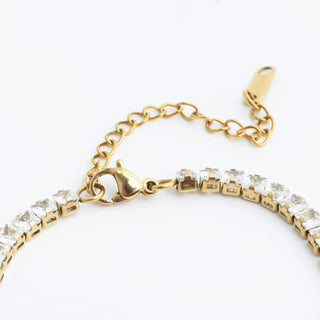 Gold bracelet with clear stones on a white background