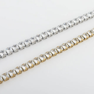 Two strands of clear rhinestone chains, one silver and one gold, on a light gray background.