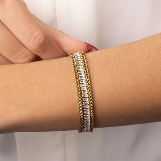 Gold and silver bracelet on a wrist against a white background