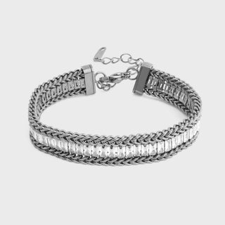 Silver bracelet with braided design on a light gray background