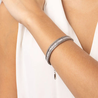 Silver bracelet on a person's wrist against a white background