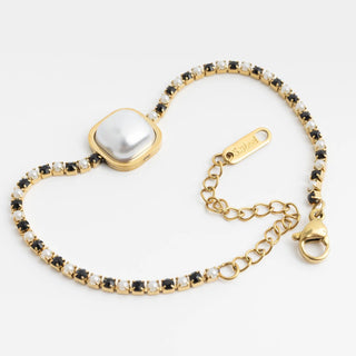 Gold bracelet with a central square gem and black and white bead accents on a light gray background