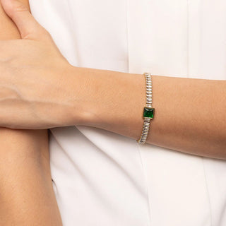 Bracelet with a green gemstone on a person's wrist against a white background