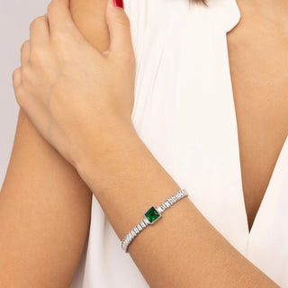 Silver bracelet with a green gemstone on a person's wrist against a white background