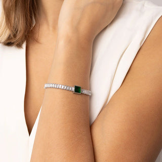 Silver bracelet with a green gemstone on a person's wrist against a white background