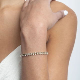 Close-up of a person's arm wearing a bracelet on a plain background