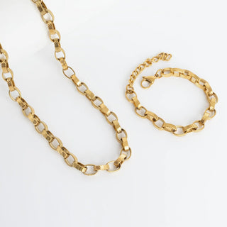 Gold chain necklace and bracelet on a white background