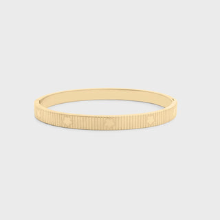 Gold bracelet on a light gray background