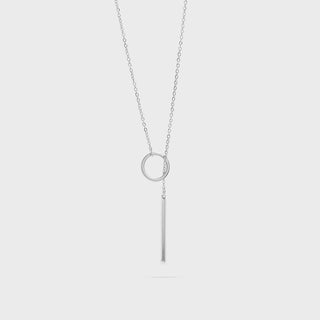 Silver necklace with circular lariat pendant on a light gray background