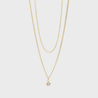 Gold necklace with a small star pendant on a light gray background