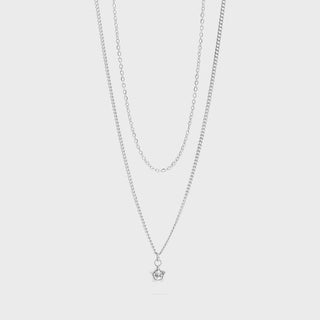 Layered silver necklaces on a white background
