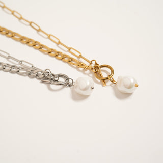 Two necklaces with pearl charms on a white background