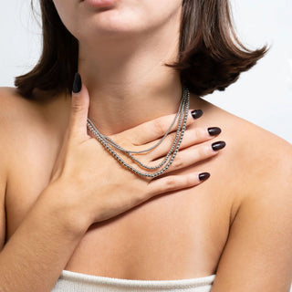 Woman wearing a silver beaded necklace with a neutral background