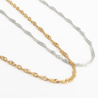 Two gold and silver Singapore Belly Chains on a white background