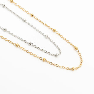 Two gold and silver Satellite Belly Chains on a white background