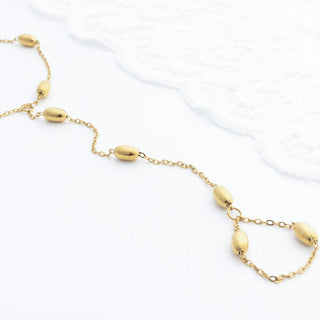 Gold Statement Bead Hand Chain with round beads on a white background