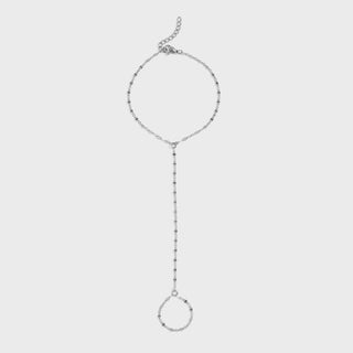 Silver hand chain on a light gray background